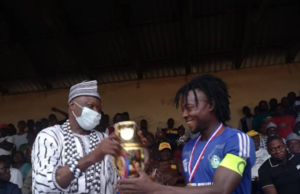 REVEREND FATHER WINS RAFFLE DRAW STAR PRIZE. …. wears shirt with inscription ” It’s been God All the Way”..
